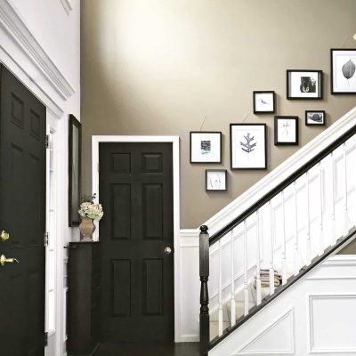 Foyer with wainscoting black doors gallery wall upstairs