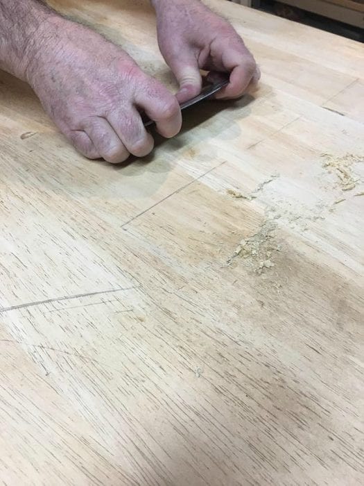 Cabinet scraper cleaning up deep scratches