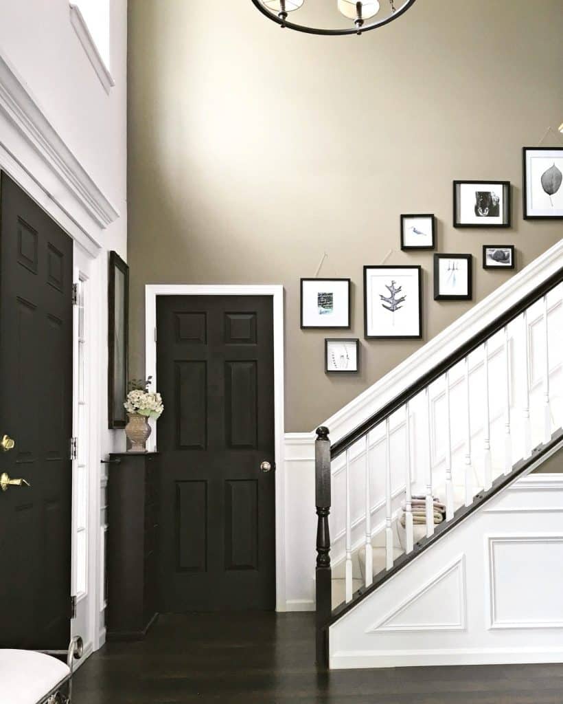 two story foyer painted dark with wainscoting and black doors